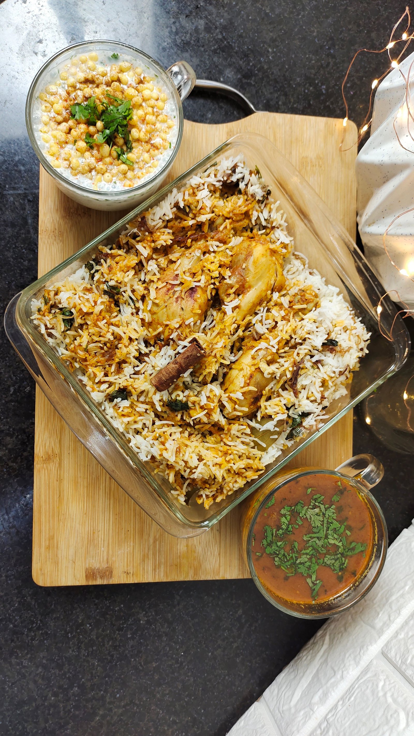 Ya Rahman biriyani spread with sides served on a rustic wooden table