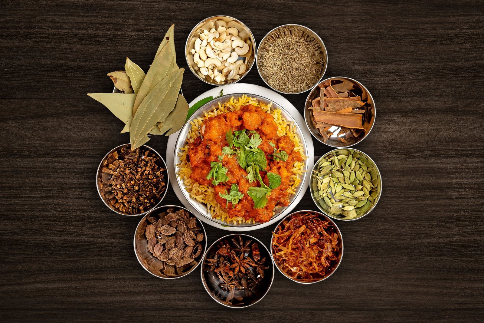 Traditional biriyani surrounded by assorted whole spices
